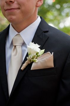 a man in a suit and tie with a boutonniere on his lapel