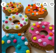 four decorated doughnuts sitting on top of a table