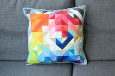 a colorful pillow sitting on top of a gray couch