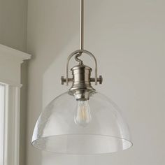 a light fixture hanging from the ceiling in a room with white walls and window sill