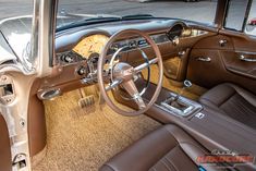 the interior of an old fashioned car with brown leather seats and steering wheel, along with dashboard