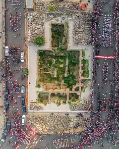 an aerial view of a street with cars and people walking around it in the middle