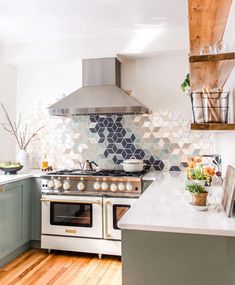 a stove top oven sitting inside of a kitchen next to a wooden countertop and white cabinets