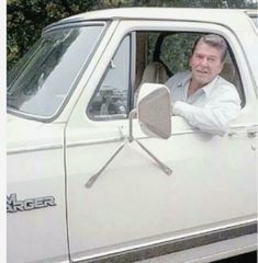 a man sitting in the driver's seat of a white truck