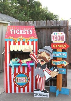 a carnival booth with signs for tickets and popcorn