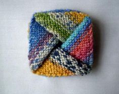 a multicolored knitted headband on a white surface