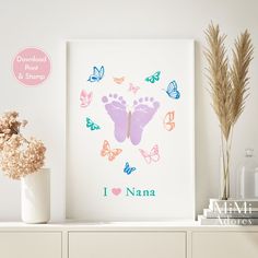 a baby's footprints and butterflies are on the wall next to a vase with flowers