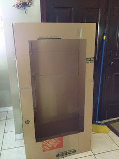 an open cardboard box sitting on the floor in front of a door with a handle