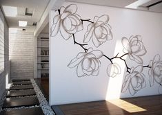 a white wall with flowers painted on it next to a wooden floor and bookshelf