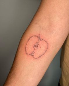 a small apple tattoo on the arm