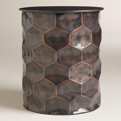 a brown and black vase sitting on top of a table