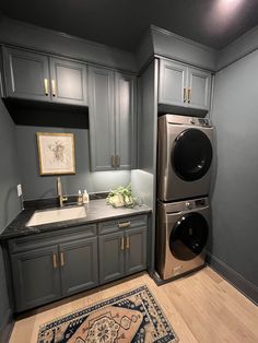 a washer and dryer sitting in a kitchen next to a rug on the floor