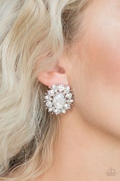 a woman with blonde hair wearing large white diamond earring in front of her face