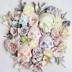 a bunch of flowers that are on top of a white surface with one flower in the middle