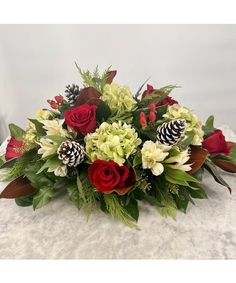 This floral centerpiece, with its combination of crimson red roses, white alstroemeria, red hypericum berries, hydrangea, and premium Christmas greens including camellia foliage, creates a stunning statement piece that embodies the spirit of celebration, making it perfect for gatherings during the holiday season. Winter Baskets, White Alstroemeria, Winter Table Centerpieces, Holiday Centerpieces Christmas, Holiday Flower Arrangements, Centerpieces Christmas, Christmas Greens, Church Christmas Decorations, Christmas Florals