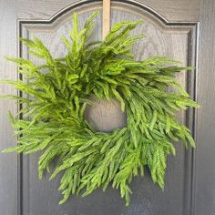 a green wreath hanging on the front door