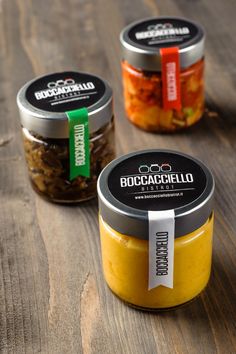 three jars of food sitting on top of a wooden table