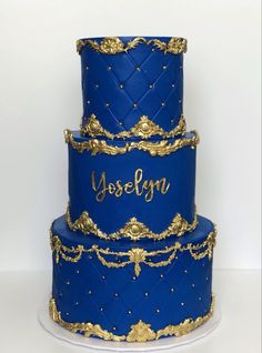 a three tiered blue cake with gold trimmings and the words yesebony on it