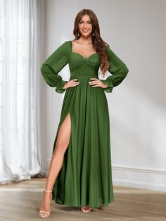 a woman in a long green dress posing for the camera with her legs on the floor