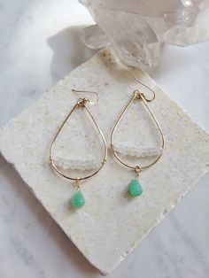 These teardrop hoops feature the beautiful semi precious stones of Chrysoprase (green) and Moonstone. This combination of gems is so pretty and beachy! Perfect for the Summertime! It adds a gorgeous touch of color to an outfit. The teardrop hoops are hand formed and lightly hammered for texture and shape. Moonstone gems are lined and wire wrapped across the bottom of the hoop while a pretty Chrysoprase gem dangles at the bottom. The length of the earrings are just a little longer than 2 1/4 in. Green Bohemian Teardrop Drop Earrings, Bohemian Green Teardrop Drop Earrings, Green Bohemian Teardrop Earrings, Bohemian Green Teardrop Earrings, Teardrop Jade Earrings With Natural Stones, Teardrop Earrings For Everyday - May Birthstone, Bohemian Teardrop Jade Earrings, Bohemian Jade Teardrop Earrings, Everyday Teardrop Earrings For May Birthstone