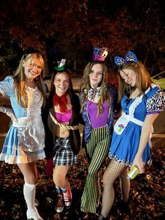 four girls dressed up in costumes posing for the camera