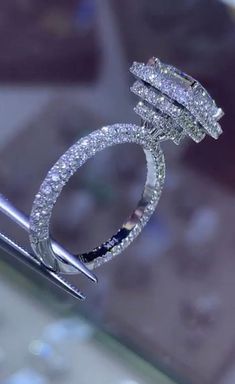 a diamond ring is being held up by a pair of scissors