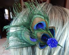 This feather hair comb is made with hand-selected exotic peacock eye feathers. This feather fascinator is approximately 6 inches long from the wispy tail feathers to the hand-beaded blue cabochon. Feather hair clip secures in hair with a comfortable alligator clip. Durable and reusable time and again for any special occasion.  This hair comb is perfect for any dance, recital, or pageant. Did you know? The peacock feathers have microscopic 'crystal-like structures' that reflect different waveleng Feather Hair Comb, Peacock Hair, Feather Fascinator, Feather Hair Clips, Feather Fascinators, Tail Feathers, Feathered Hairstyles, Peacock Feathers, Peacock Feather