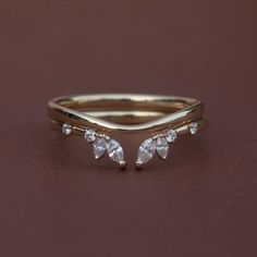 a gold ring with three pear shaped diamonds on the top and two smaller pears on the bottom