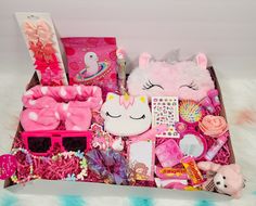 a pink box filled with lots of toys and stuff on top of a fur rug