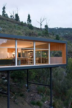 an image of a house that is on the side of a hill with trees around it