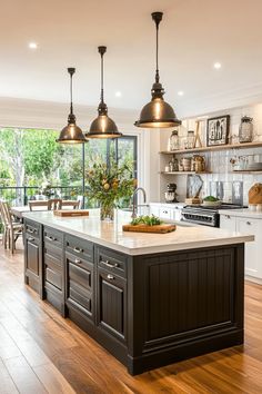 a large kitchen with an island in the middle and lots of lights hanging above it