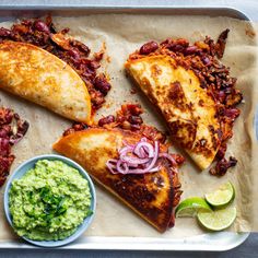 some tacos and guacamole on a tray