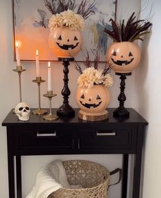 three pumpkins sitting on top of a table with flowers and candles in front of them