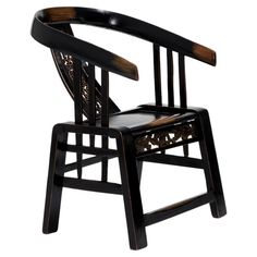 a wooden chair with black leather upholstered on the seat and back, against a white background