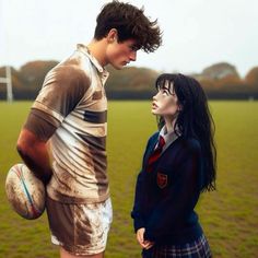 a young man and woman standing in front of a soccer ball on a green field