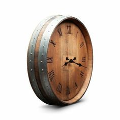 a wooden barrel clock with roman numerals on the face is shown against a white background