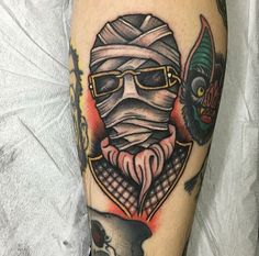 a man's leg with a tattoo on it and an image of a mask