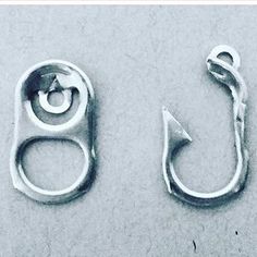 two metal hooks with an arrow on the top and one hook attached to it's side