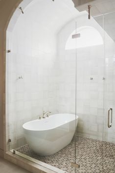 a white bath tub sitting inside of a bathroom next to a walk in shower