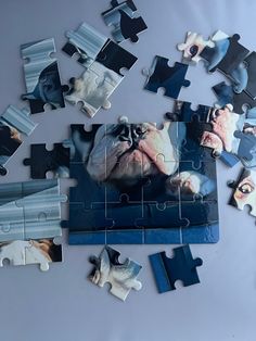 the puzzle is made up of pieces of blue and white jigsaw with an image of a dog on it