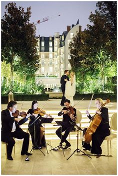 a group of people that are playing violin