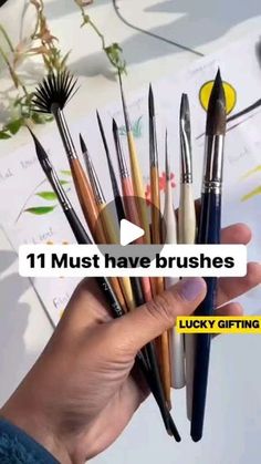 a person holding a bunch of brushes in their hand