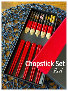 the chopstick set in its box is red and has six different colored wooden sticks