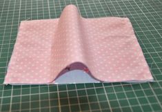 a pink and white polka dot cloth on a cutting board