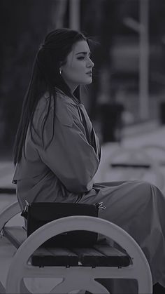 a woman sitting on top of a car next to a steering wheel and looking off into the distance