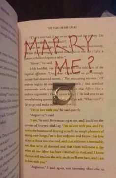 an open book with the words marry me? written in red and black ink on it