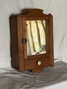 an old wooden medicine cabinet with a mirror on it