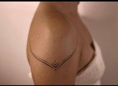 a woman's shoulder with a small tattoo on the left side of her arm