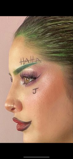 a woman with green hair and makeup has the words hail written on her face in black ink