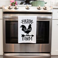 a kitchen towel that says farm sweet farm hanging on the front of an oven door